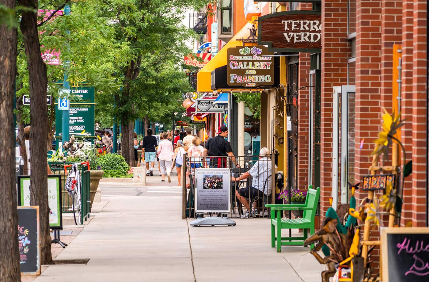 sidewalk view of a busy and colorful downtown shopping district
